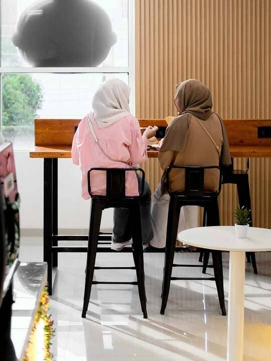 Friends enjoying coffee at the wooden window counter